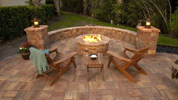 Patio with fire pit with flames during day time.