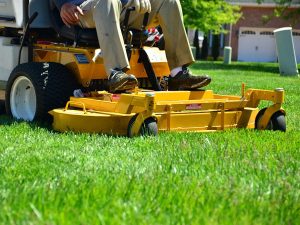 Professional riding lawn mower, mowing residential grass.