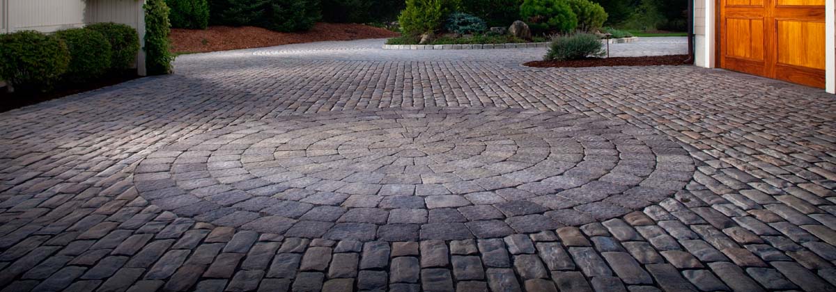 Cobblestone pavers near the garage door of a house.